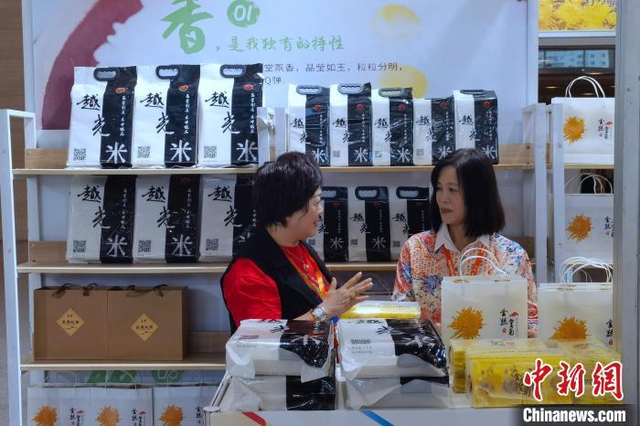 参展本届农订会的台湾客商卢月香(左)介绍“越光米”品种和技术。中新网记者孙虹 摄