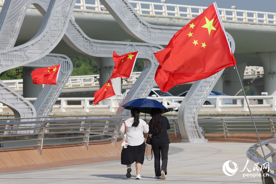 游客在厦门演武大桥星光大道上与国旗同框。人民网记者 陈博摄