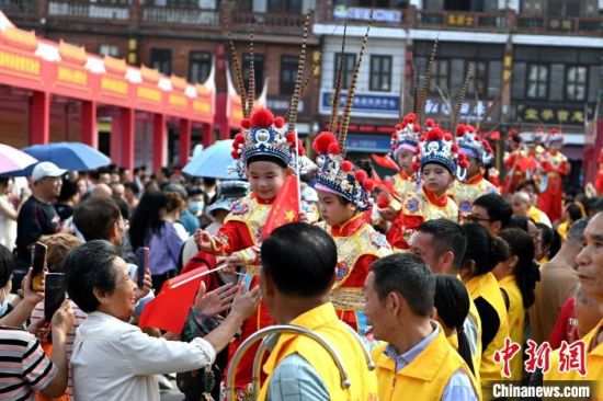 图为“踩高跷”非遗传统技艺在漳州古城展演，吸引不少游人驻足观赏拍照。中新社记者 张金川 摄